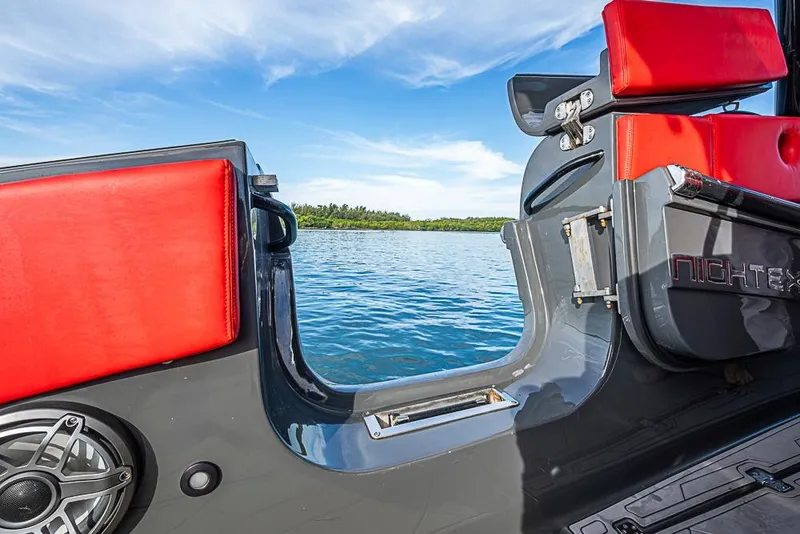 Slide: The Image of 2021 Midnight Express 43 Solstice boat with red seating, open door, and scenic water view. - 13