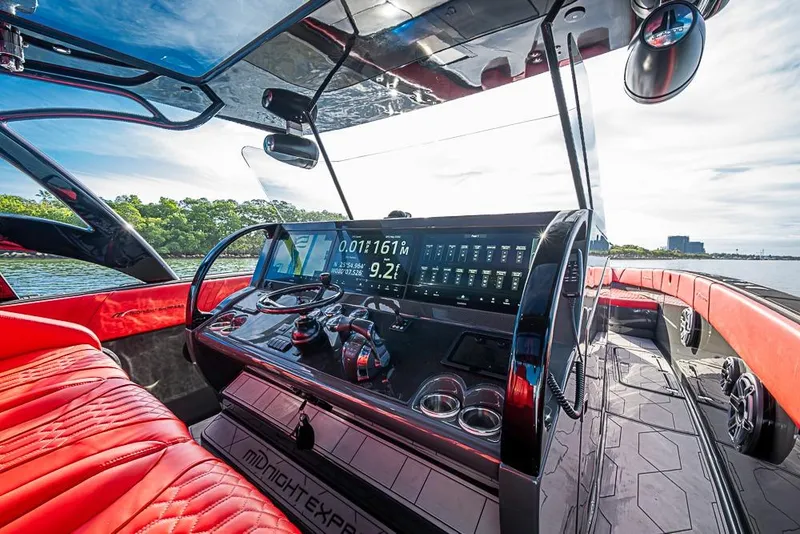 Slide: The Image of Cockpit of 2021 Midnight Express 43 Solstice boat with modern controls and red seating. - 18