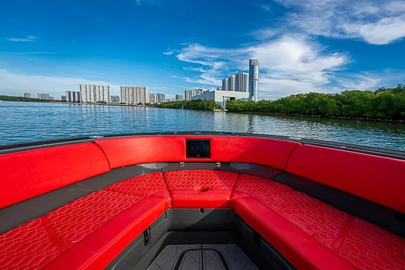 Slide: The Image of Luxurious 2021 Midnight Express 43 Solstice boat with red seating, city skyline view. - 29