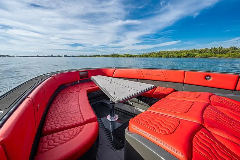 Slide: The Image of Luxurious 2021 Midnight Express 43 Solstice boat with red seating on a serene lake. - 3