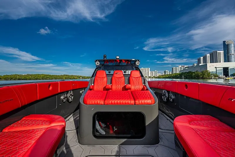 Slide: The Image of Luxurious 2021 Midnight Express 43 Solstice boat with vibrant red seating and city skyline backdrop. - 31