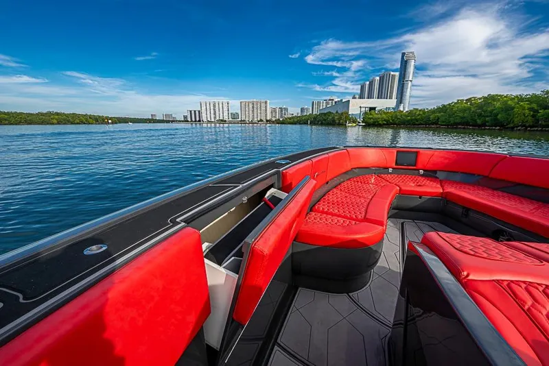 Slide: The Image of Luxurious 2021 Midnight Express 43 Solstice boat with red seating, city skyline view. - 33