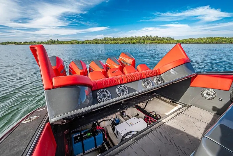 Slide: The Image of 2021 Midnight Express 43 Solstice boat with red seating and open engine compartment on a lake. - 8