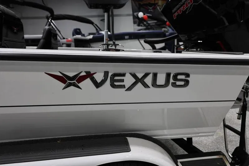 Slide: The Image of 2026 Vexus AVX 2100 boat side view with logo in showroom setting. - 19