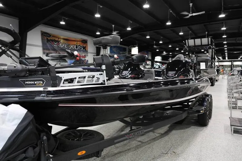 Slide: The Image of 2026 Vexus VXs21 boat displayed indoors, featuring Minn Kota motor and sleek black design. - 10