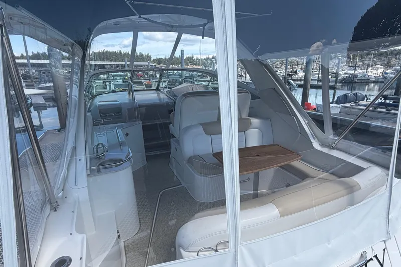 Slide: The Image of 2008 Sea Ray Sundancer 310 interior with seating and table, docked at marina. - 2