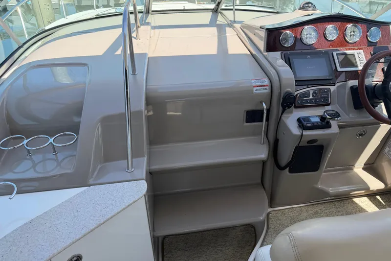 Slide: The Image of 2008 Sea Ray Sundancer 310 helm with controls, gauges, and cup holders. - 21