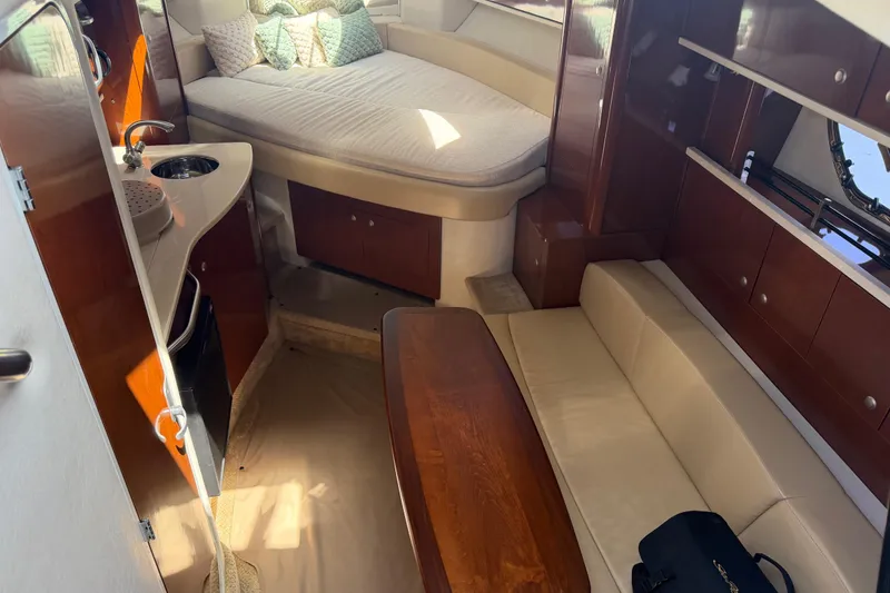 Slide: The Image of Interior of 2008 Sea Ray Sundancer 310 with cozy seating and compact kitchenette. - 23