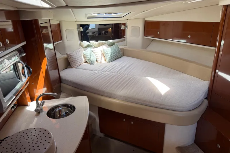 Slide: The Image of 2008 Sea Ray Sundancer 310 cabin interior with bed, kitchenette, and wood finish. - 24