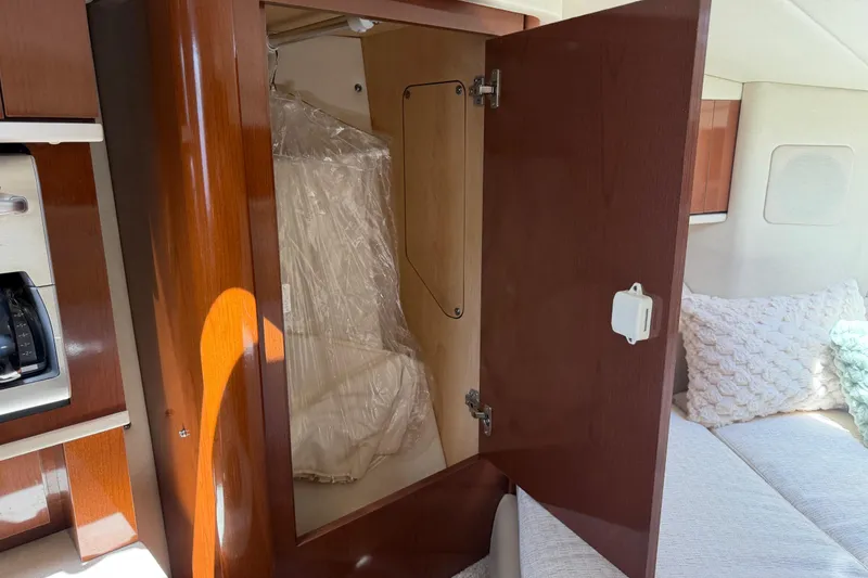 Slide: The Image of Interior cabin of 2008 Sea Ray Sundancer 310 with open wooden cabinet. - 26