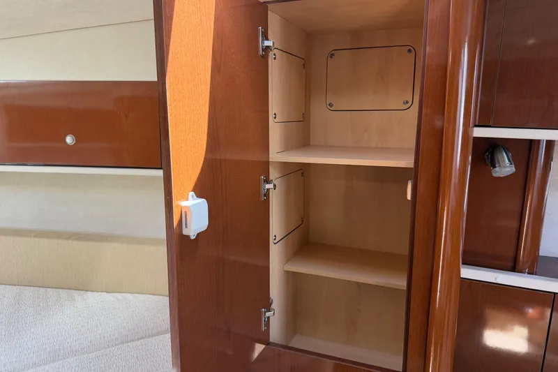 Slide: The Image of Interior cabinet of 2008 Sea Ray Sundancer 310 yacht, featuring wooden shelves and sleek design. - 27