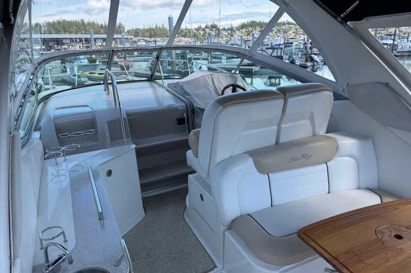 Slide: The Image of 2008 Sea Ray Sundancer 310 interior with white seating and wooden table, docked at marina. - 3