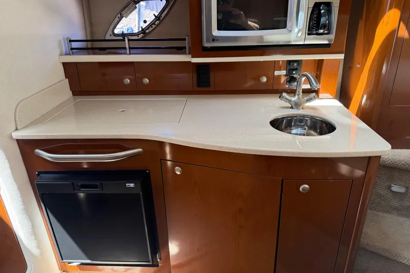 Slide: The Image of 2008 Sea Ray Sundancer 310 interior kitchen with sink, microwave, and compact fridge. - 31