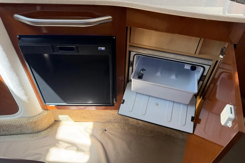 Slide: The Image of 2008 Sea Ray Sundancer 310 interior with fridge and open storage compartment. - 32