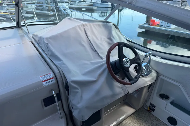 Slide: The Image of 2008 Sea Ray Sundancer 310 helm with covered dashboard and steering wheel at marina. - 4