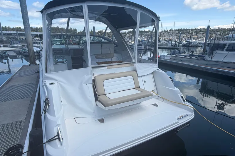Slide: The Image of 2008 Sea Ray Sundancer 310 docked at marina, featuring spacious seating and covered cockpit. - 48