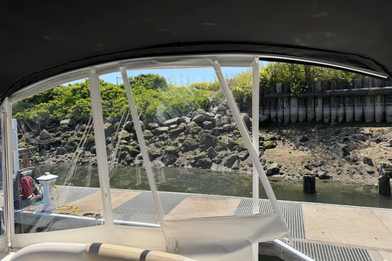 Slide: The Image of View from a 2008 Sea Ray Sundancer 310, docked near a rocky shoreline. - 50