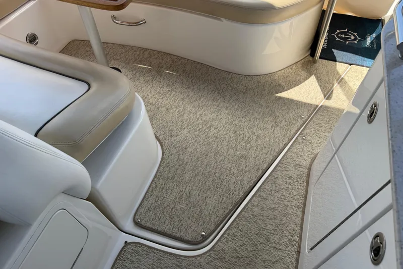 Slide: The Image of Interior of a 2008 Sea Ray Sundancer 310 boat, featuring beige seating and carpet. - 52
