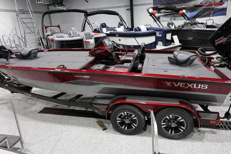 Slide: The Image of 2026 Vexus AVX 2100 boat in showroom, red color, dual-axle trailer, modern design. - 30