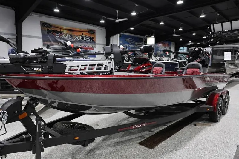 Slide: The Image of 2026 Vexus AVX 2100 boat in showroom, red and silver design, on trailer. - 8