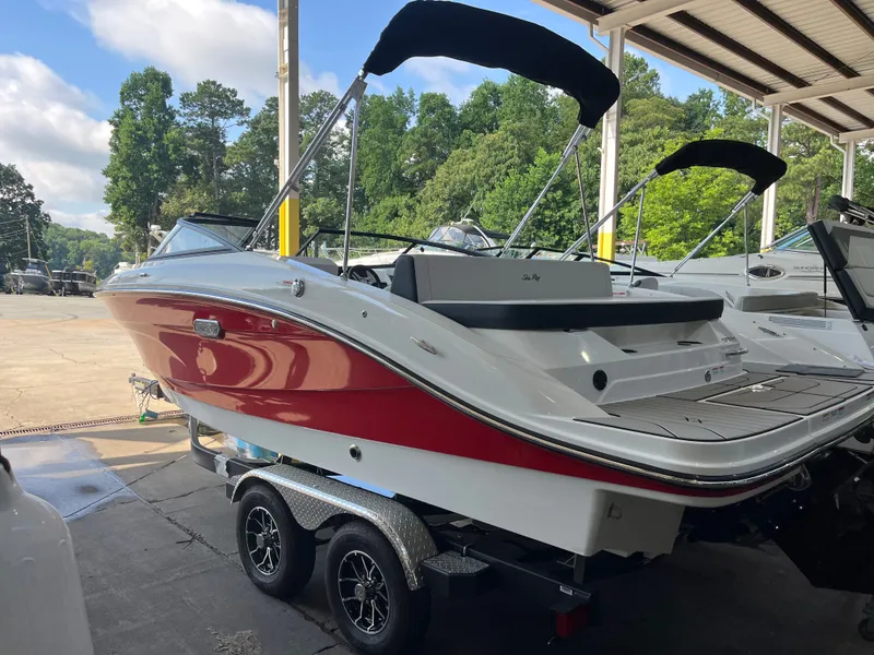 Slide: The Image of A 2026 Sea Ray SPX 210 boat on a trailer in a marina area. - 1