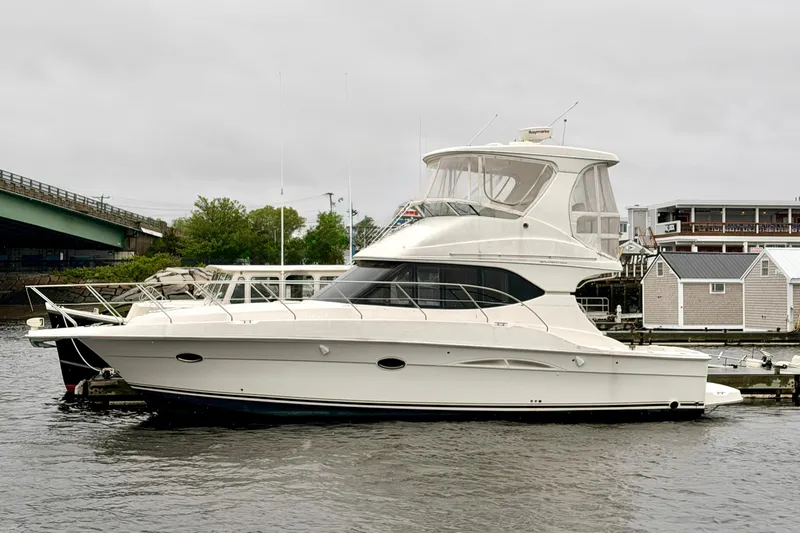 The Image of 2006 Silverton 38 Convertible yacht docked in a marina, overcast sky. - 0