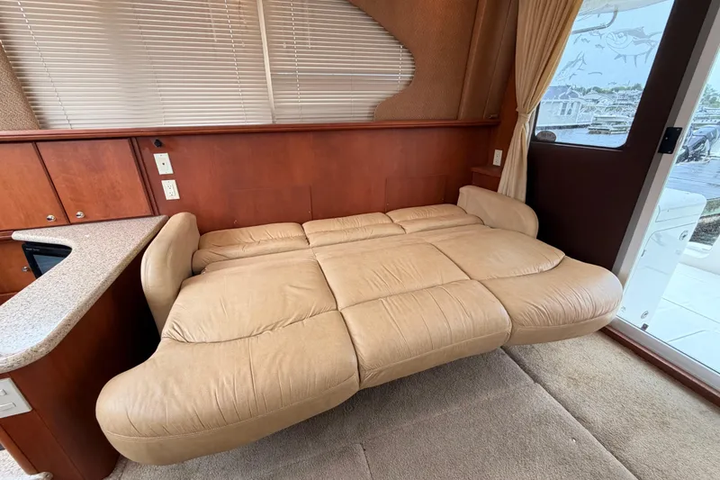 Slide: The Image of Luxurious interior of 2006 Silverton 38 Convertible yacht with beige leather sofa bed. - 14