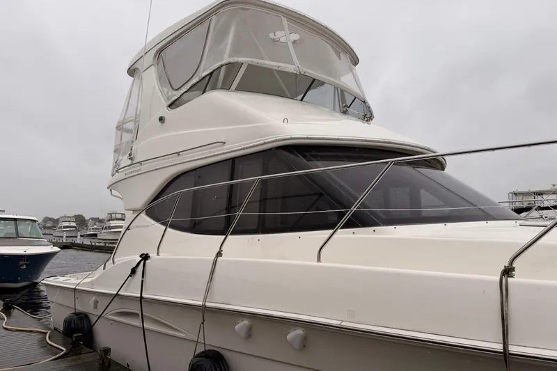 Slide: The Image of 2006 Silverton 38 Convertible yacht docked on a cloudy day. - 2