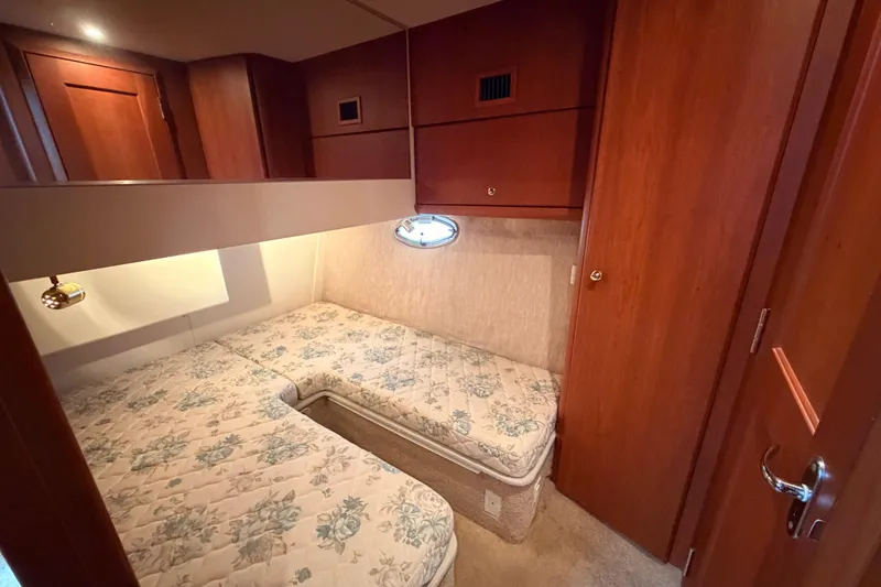 Slide: The Image of 2006 Silverton 38 Convertible cabin with twin beds and wooden cabinetry. - 21