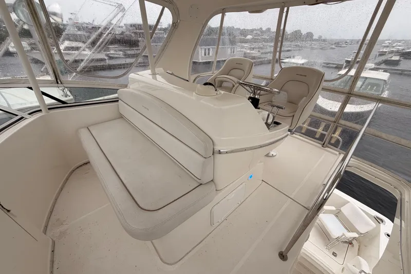 Slide: The Image of 2006 Silverton 38 Convertible yacht helm with seating, overlooking marina on a rainy day. - 22