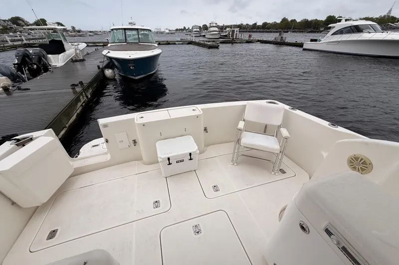 Slide: The Image of 2006 Silverton 38 Convertible yacht docked at marina, featuring spacious deck area. - 3