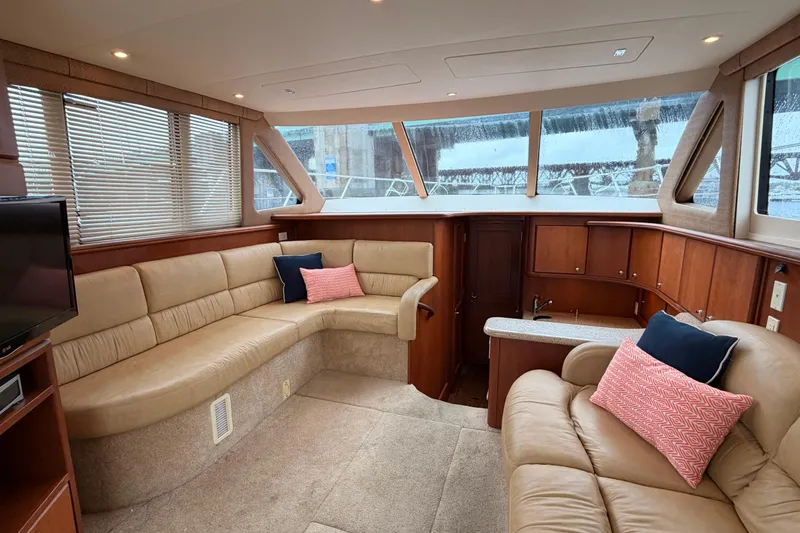 Slide: The Image of Luxurious interior of a 2006 Silverton 38 Convertible yacht with beige seating and wood accents. - 8
