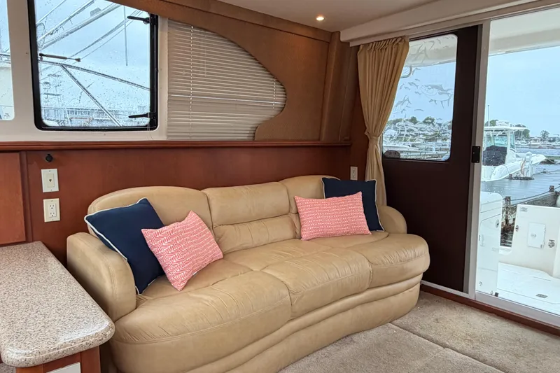 Slide: The Image of Interior of 2006 Silverton 38 Convertible yacht with beige sofa and decorative pillows. - 9