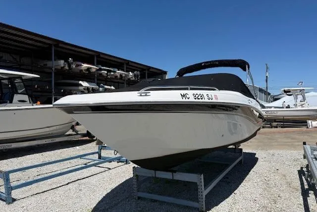 Slide: The Image of 2002 Four Winns 220 Horizon boat on display in a marina under clear blue skies. - 1