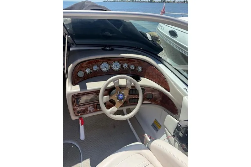 Slide: The Image of 2002 Four Winns 220 Horizon boat dashboard with wood accents and steering wheel. - 13