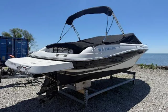 Slide: The Image of 2002 Four Winns 220 Horizon boat on trailer by the water, under clear blue sky. - 4
