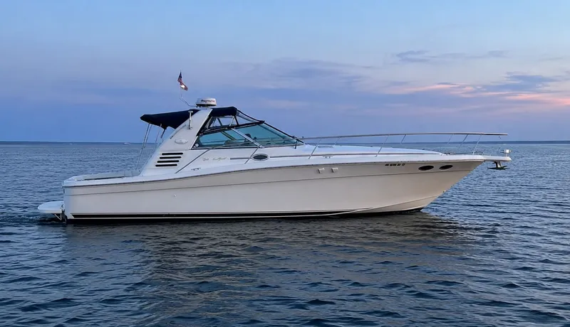 The Image of 1999 Sea Ray 370 Express Cruiser on calm water at sunset. - 0