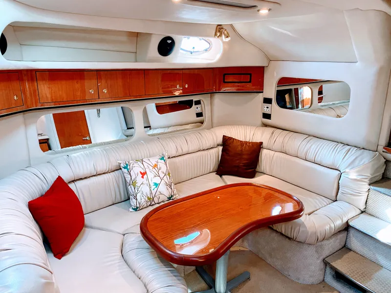 Slide: The Image of Interior of 1999 Sea Ray 370 Express Cruiser with leather sofa and wooden table. - 22