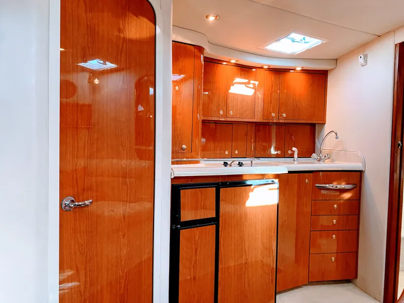 Slide: The Image of Interior of 1999 Sea Ray 370 Express Cruiser with wooden kitchen. - 28