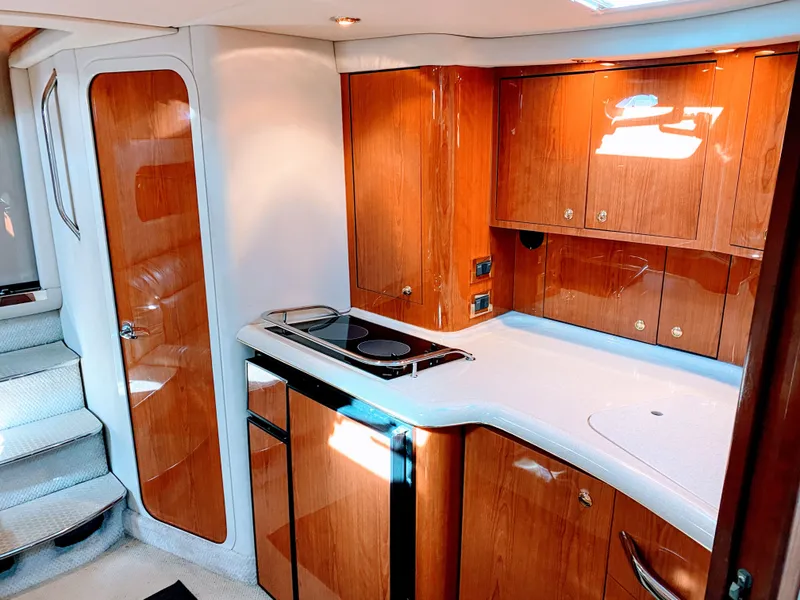 Slide: The Image of 1999 Sea Ray 370 Express Cruiser interior with wooden cabinetry. - 29
