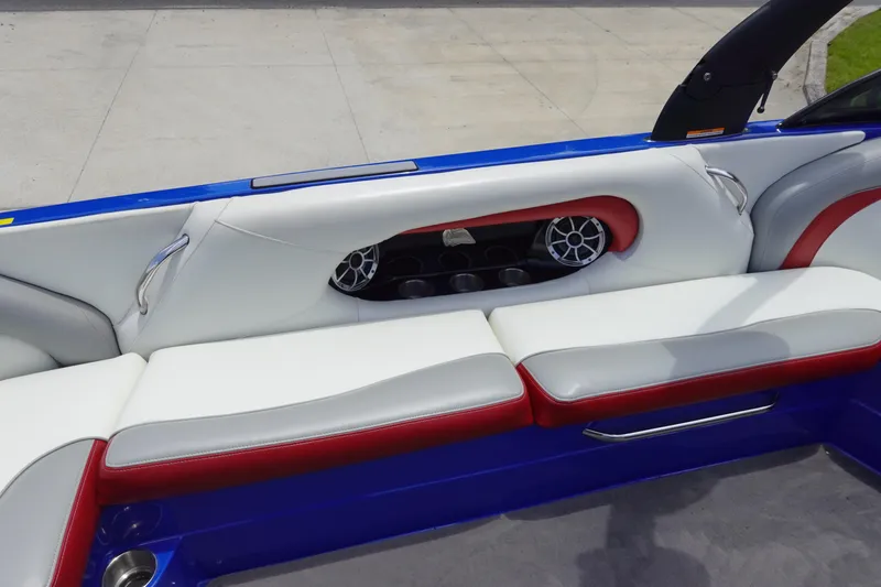 Slide: The Image of 2013 Centurion Enzo SV244 boat interior with white and red seating, cup holders, and speakers. - 10