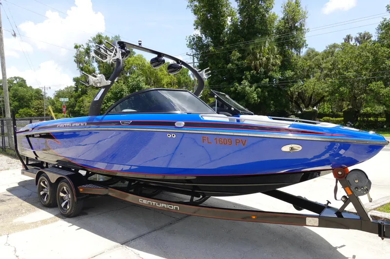 Slide: The Image of 2013 Centurion Enzo SV244 boat in vibrant blue on a trailer, parked outdoors. - 3