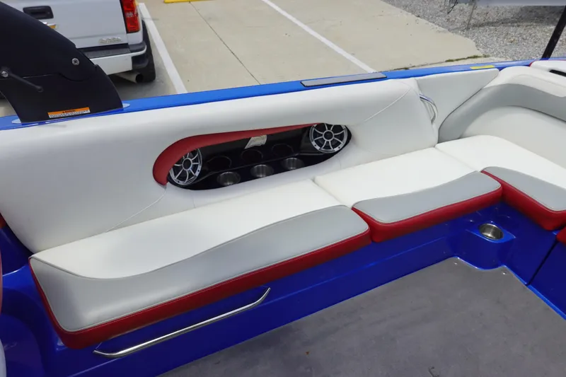 Slide: The Image of 2013 Centurion Enzo SV244 boat interior with white and red seating, cup holders, and speakers. - 9