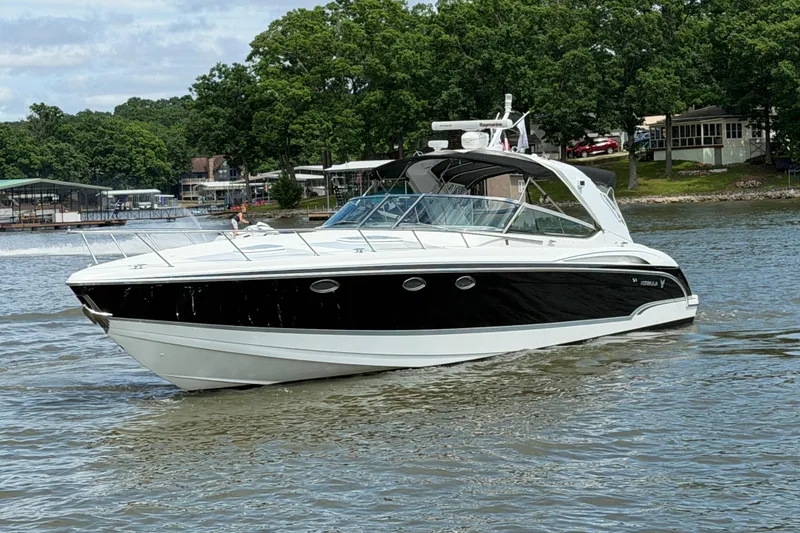 Slide: The Image of 2006 Formula 400 Super Sport boat cruising on a lake with lush green shoreline. - 2