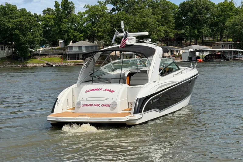 Slide: The Image of 2006 Formula 400 Super Sport boat cruising on a lake near docks and trees. - 4