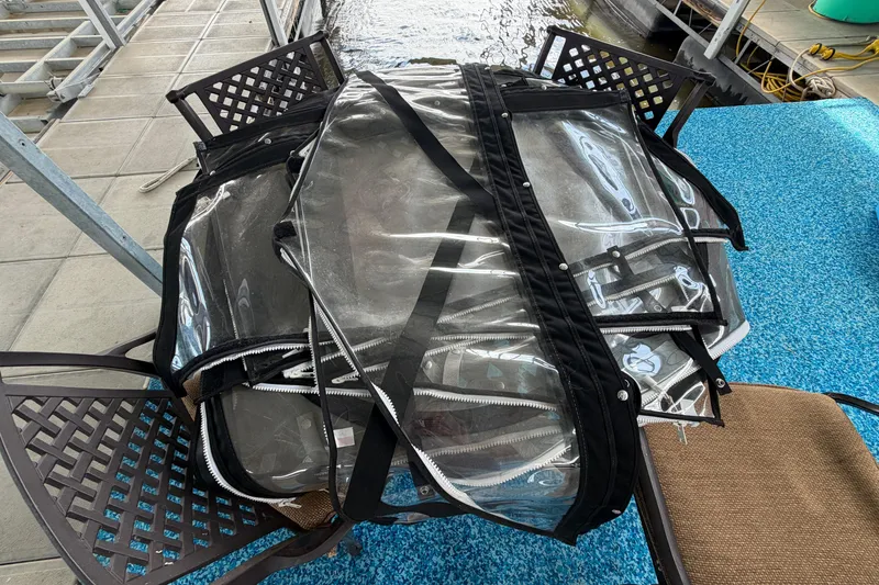 Slide: The Image of Clear boat cover for 2006 Formula 400 Super Sport on patio chairs near water. - 46