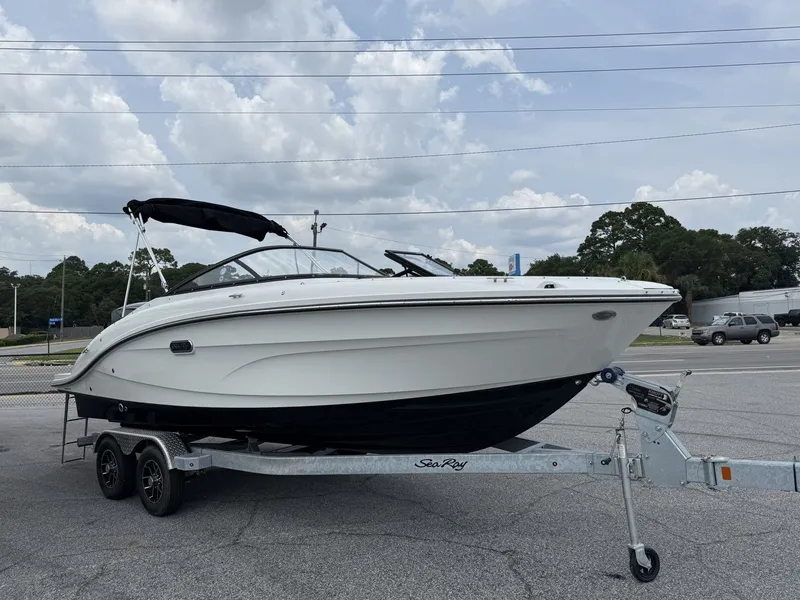 Slide: The Image of A 2026 Sea Ray SPX 210 Outboard on a trailer. The sky is cloudy. - 0
