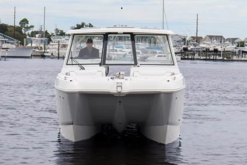 Slide: The Image of Manufacturer Provided Image: 2026 World Cat 325 DC boat on water, front view, marina background. - 1