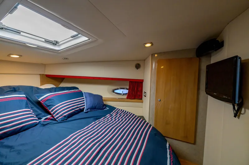 Slide: The Image of Luxurious interior cabin of a 2010 Formula 45 Yacht with striped bedding and porthole. - 31