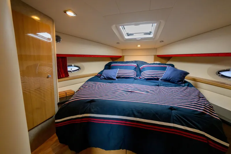 Slide: The Image of Luxurious bedroom interior of 2010 Formula 45 Yacht with striped bedding and porthole windows. - 35